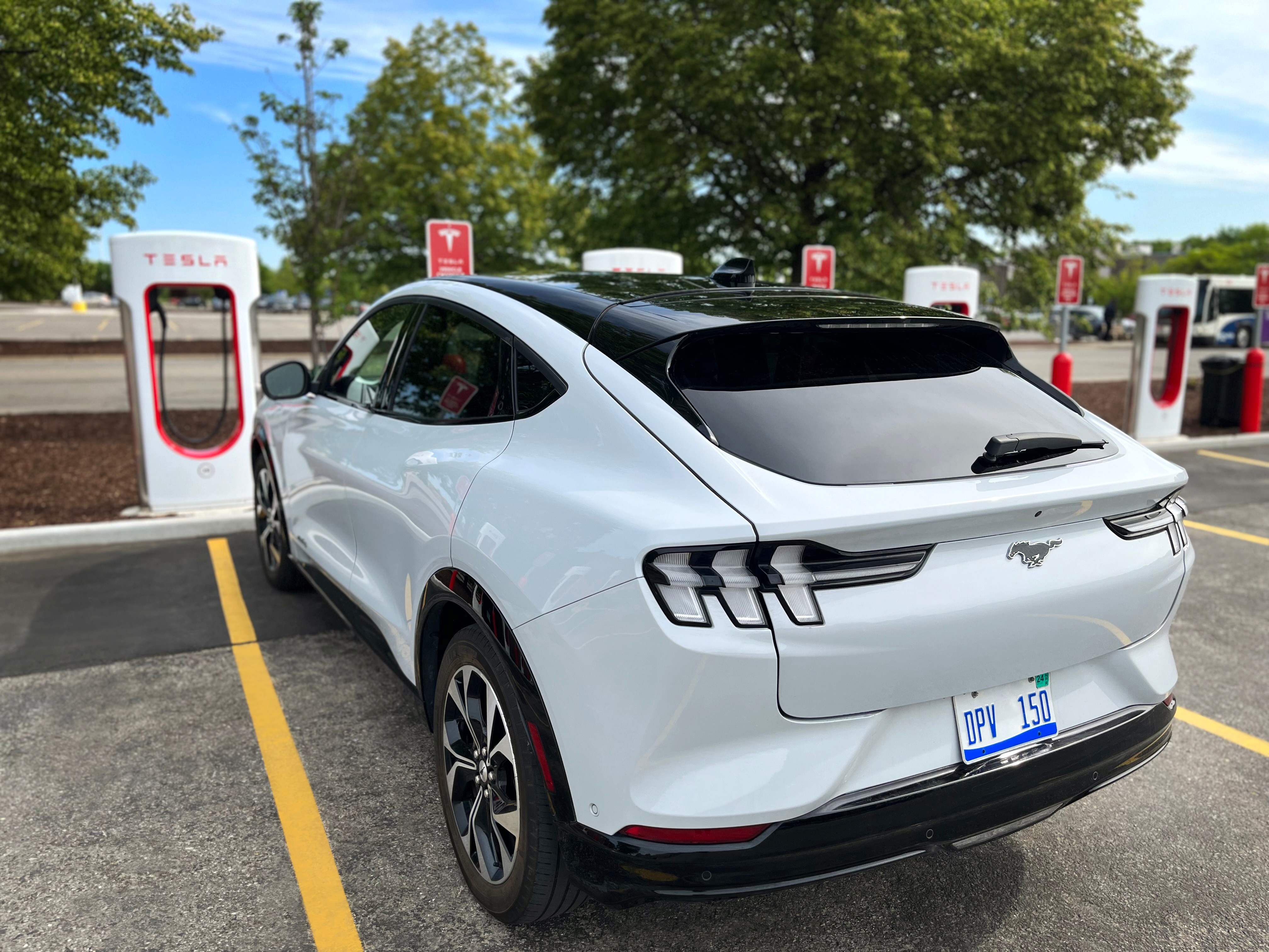 A Mustang Mach-E at at Tesla charging station.